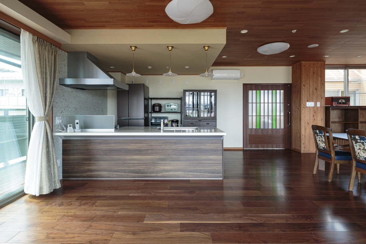 高齢者施設採用メッセージケア衝撃吸収フローリングスマートセーフティ挽き板ブラックウォルナット のフローリング画像とthe wallブラックチェリー突き板Rタイプの壁材画像